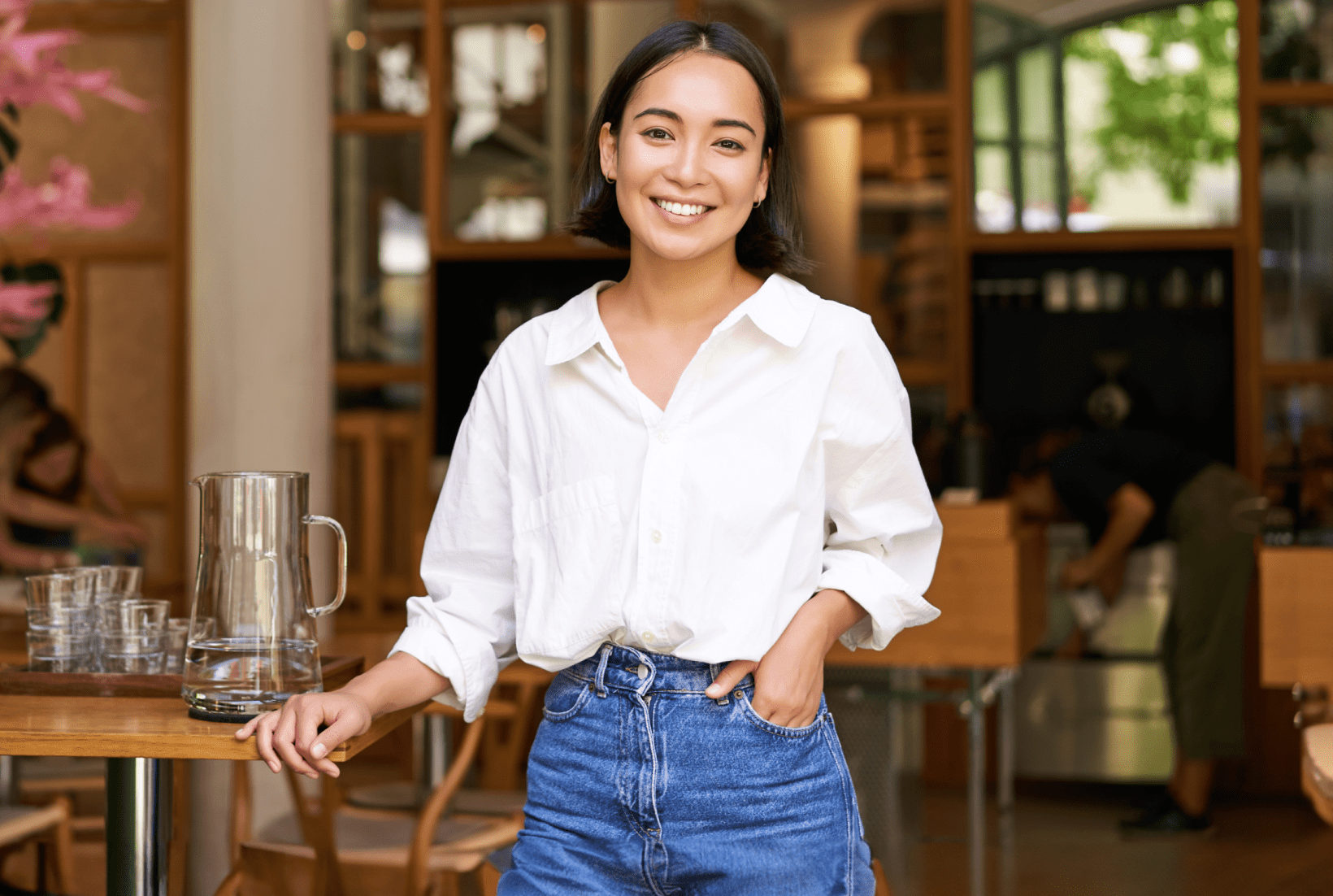 portrait-young-businesswoman-her-own-cafe-manager-standing-near-entrance-inviting-you 1-min